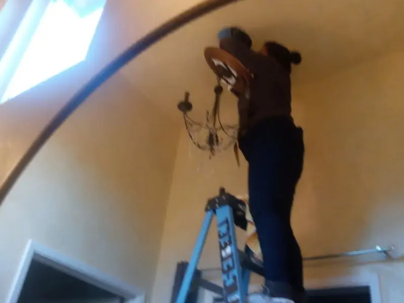 Electrician installing a chandelier in a Pistakee Highlands residence